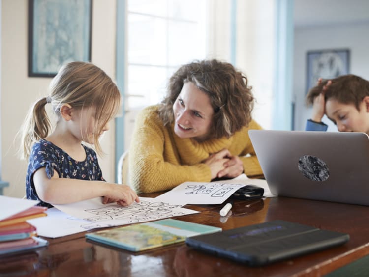 Parent with young kids on laptops celebrating a recent success in class