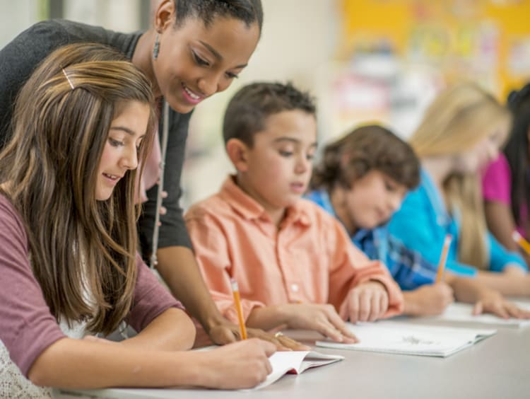 middle school teacher working with group of students