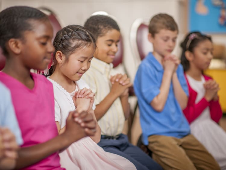 kids praying in school classroom
