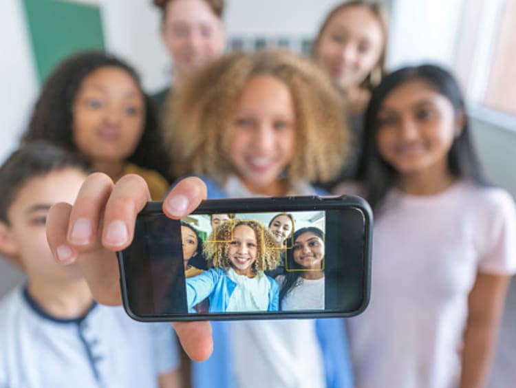 Teacher and students taking selfie for social media in classroom
