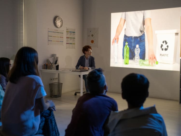 A teacher presenting an anticipatory set about recycling through a video