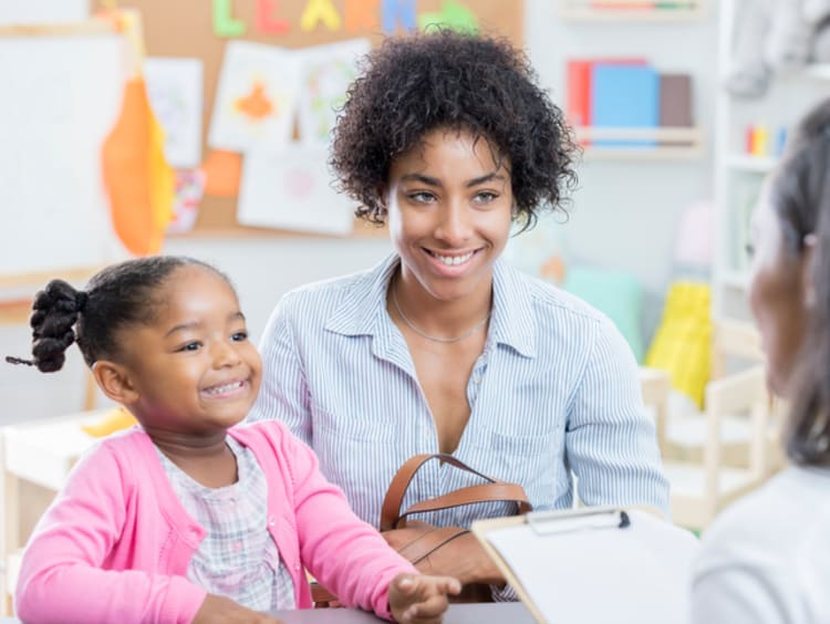 A teacher holding a conference with a student and her mother