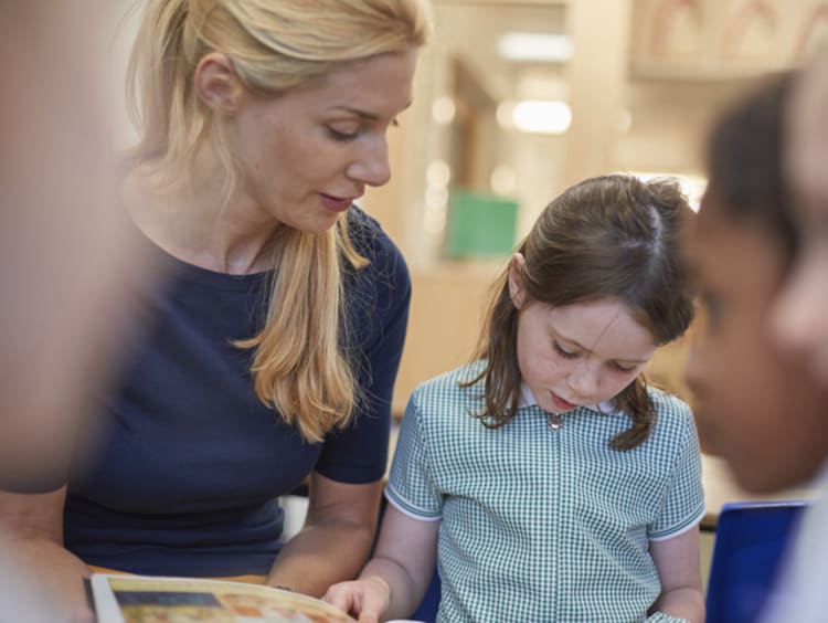 Teacher using scaffolding instruction strategies with a young student