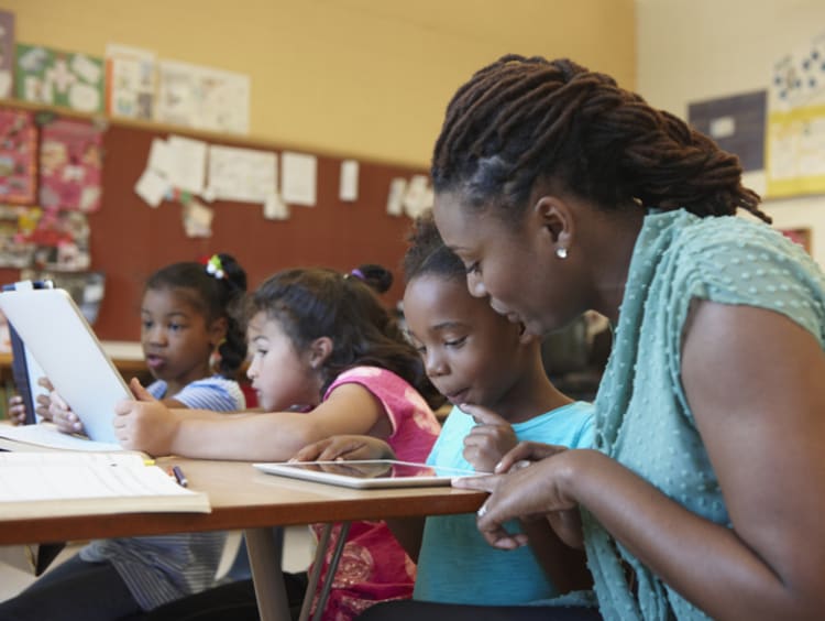 Female teacher and students in classroom doing gratitude exercises