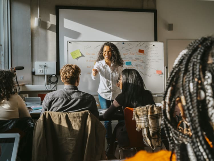 A smiling teacher using humor with students in a classroom