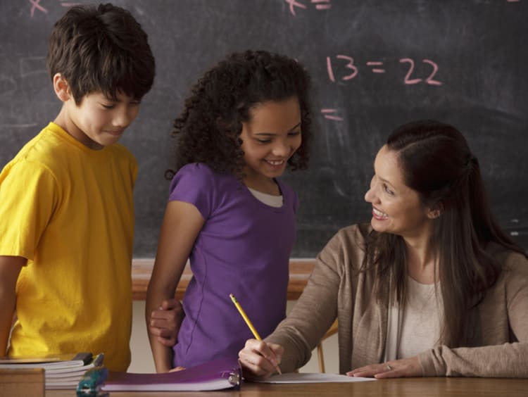 female teacher working with young co-ed students on practicing gratitude