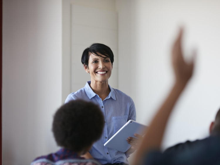 female teacher smiling in class to create happy learning environment