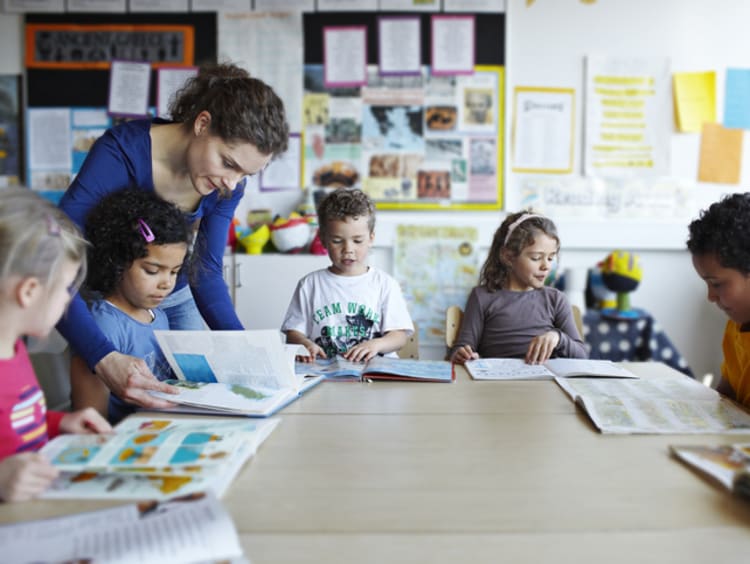 female teacher working with young students in the classroom