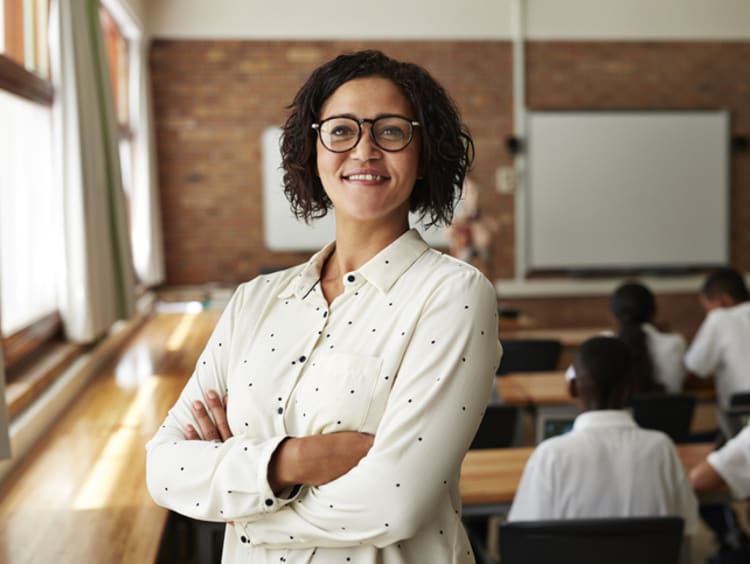 female teacher smiling in front of students in classroom