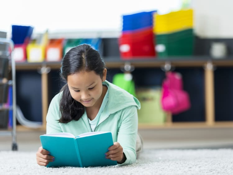 A young student utilizing a quiet space by reading  