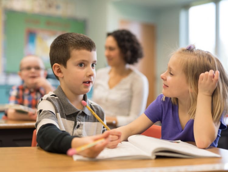 Two young students working together in class