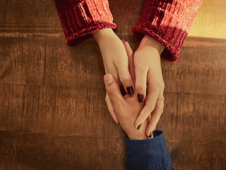 Woman hands enclasps a male hand