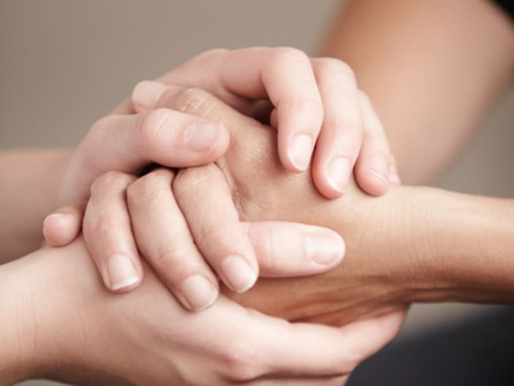 Women holding hands in prayer