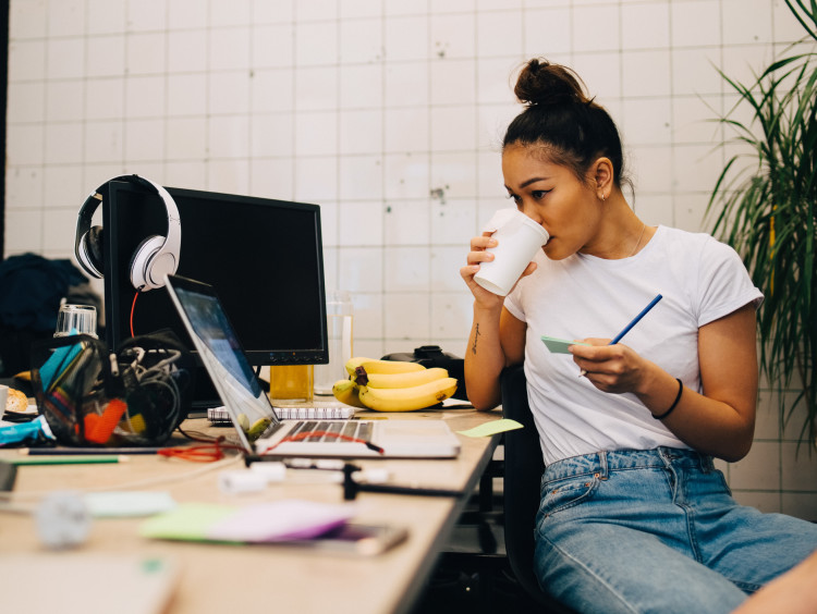 Woman drinking coffee at desk