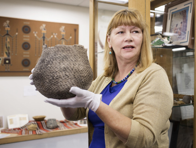 Woman holding a woven basket in museum