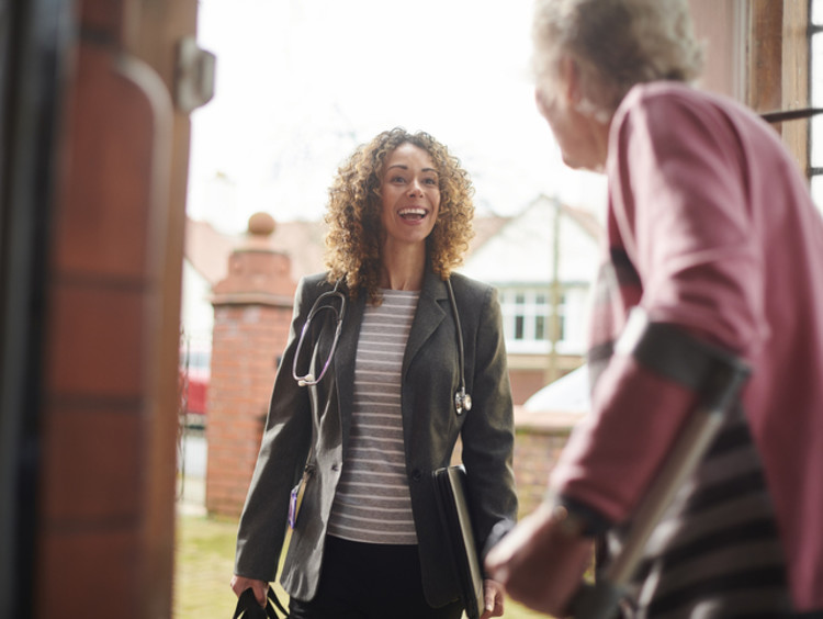 Young woman standing at door with elderly woman.
