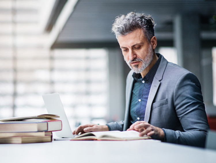 businessman studying a book outside