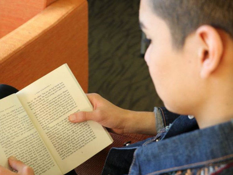 A GCU student reading in the library