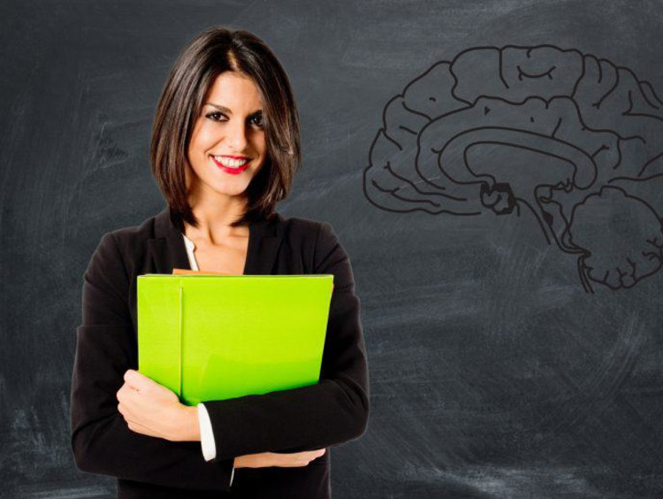 Confident business woman holds bright green folder in front of chalkboard with a brain drawn on it
