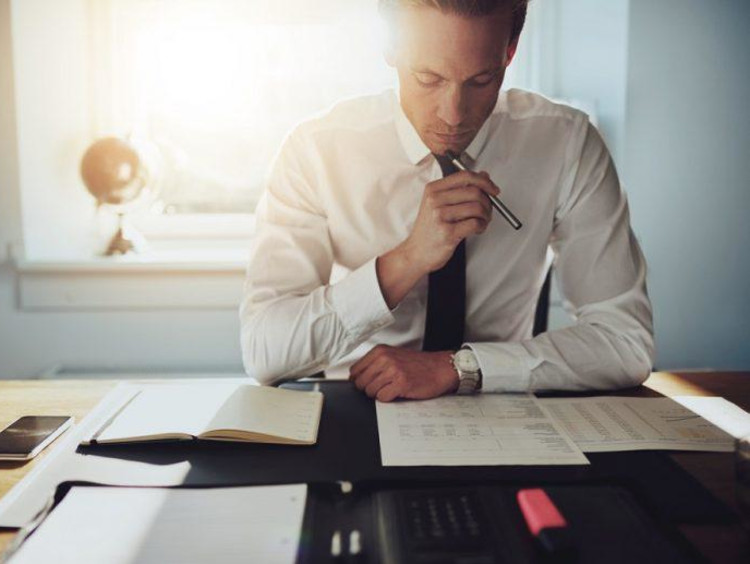 Businessman looks over financial worksheets