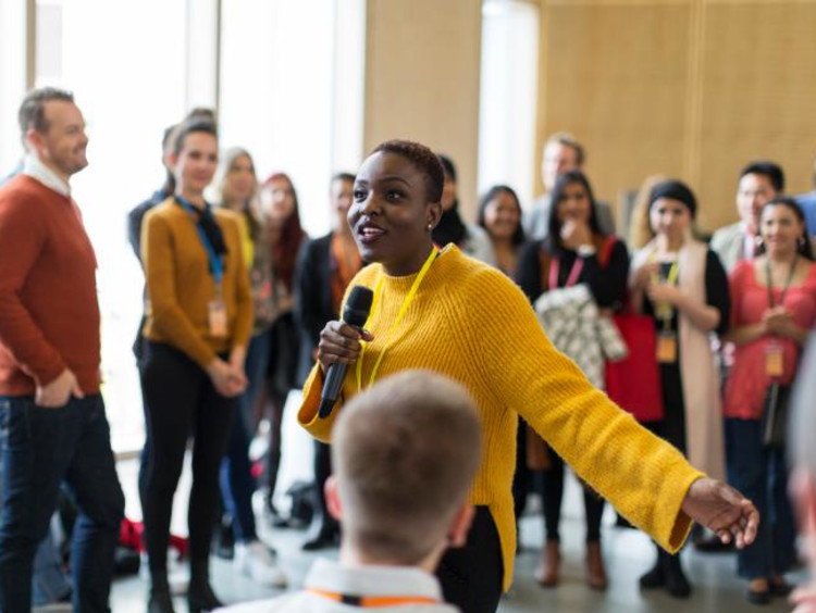 Female leader speaking on a microphone in an informal setting