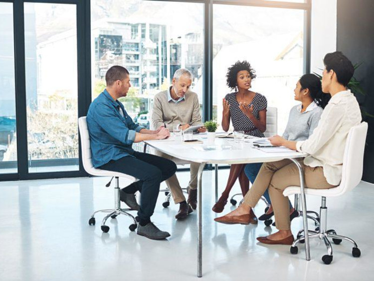 Business leadership team meets at a small conference room table