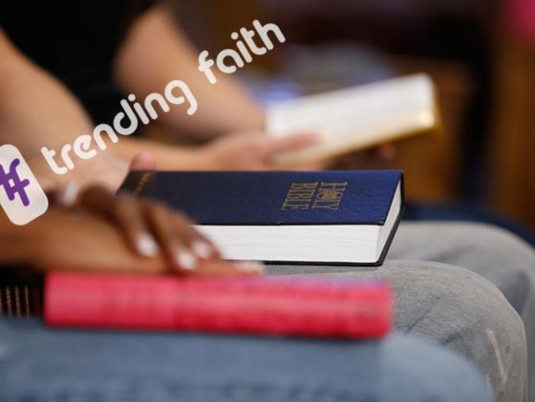 Group of students in church rows with Bibles in laps