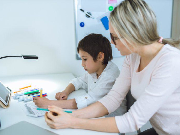 Woman teacher tutoring one student