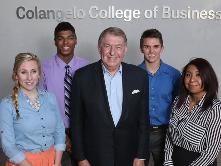 Jerry Colangelo and some business students stand in the CCOB lobby