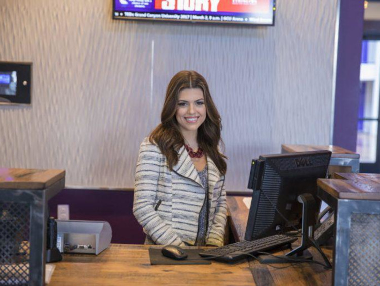 Front desk clerk of the GCU Hotel smiles