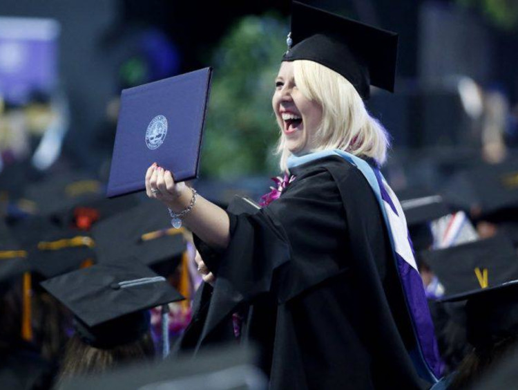 girl excited holding up diploma