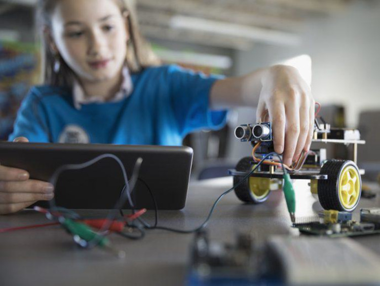 Young girl working on a robot