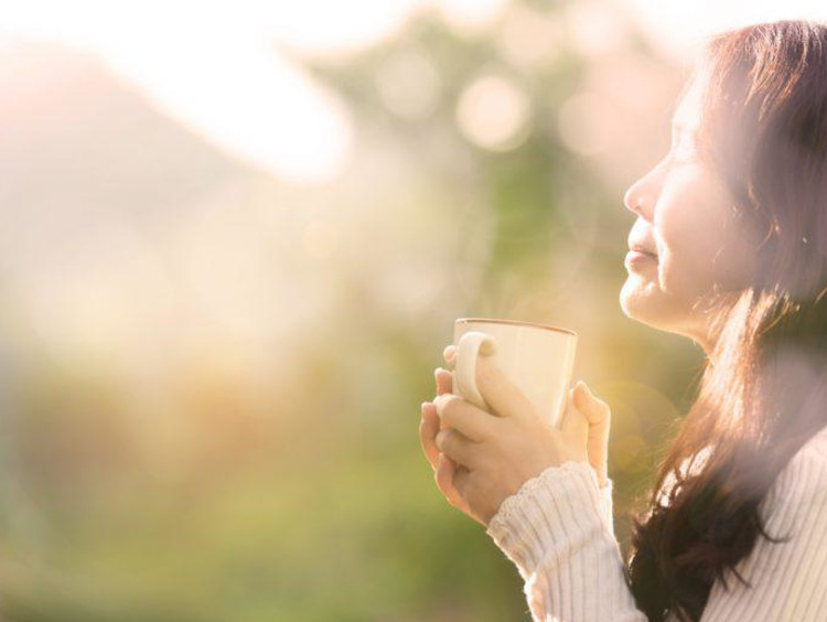 woman holding a coffee cup outside