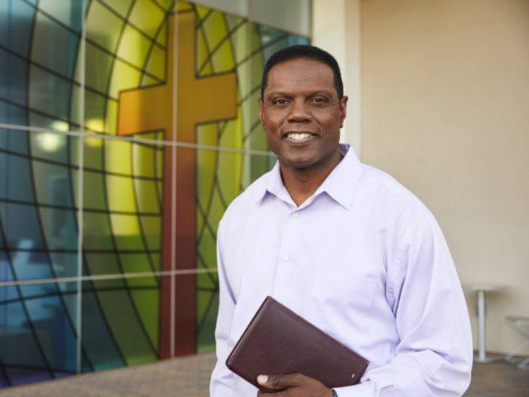 Man with a Bible in front of GCU's College of Theology
