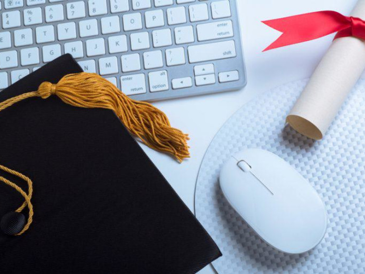 Grad cap sitting on top of a keyboard