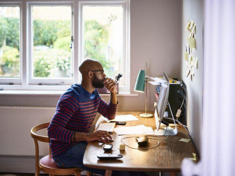 Man at desk by window with computer