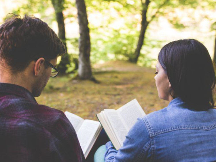 Two young adults reading scripture together.