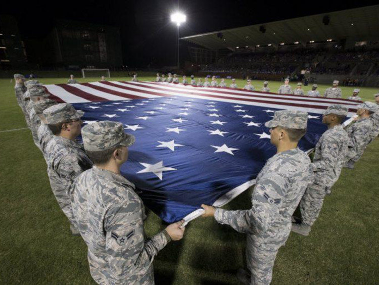 Military members holding the flag