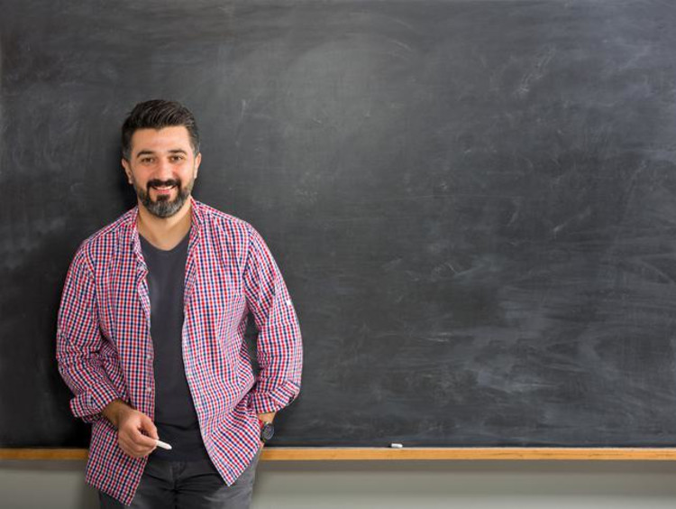 teacher standing next to chalkboard