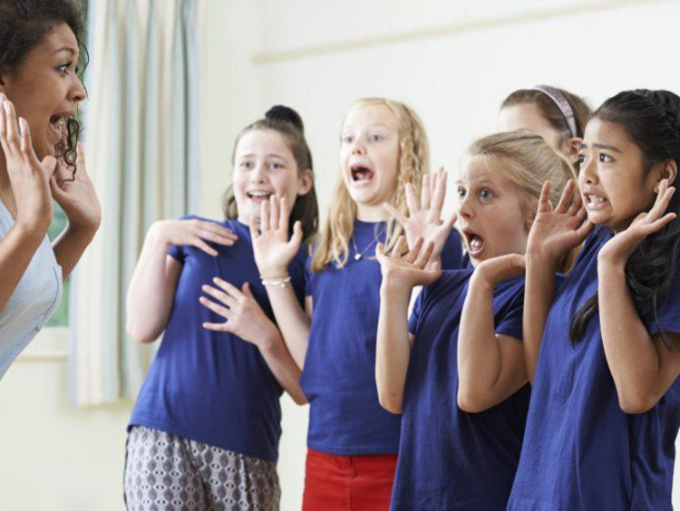 teacher pretending to scaring children in acting class