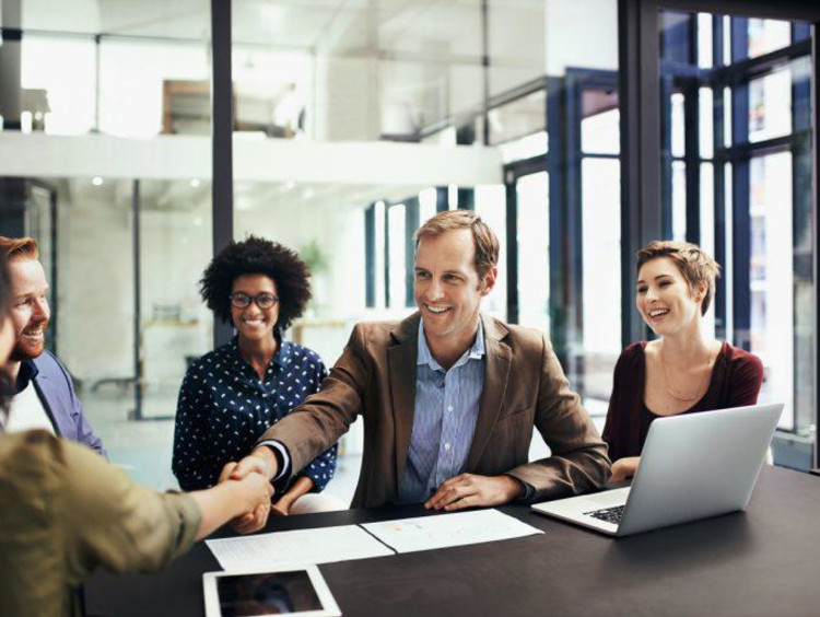a group of people at a table shaking hands