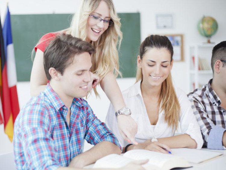 Students and teacher interacting with a textbook