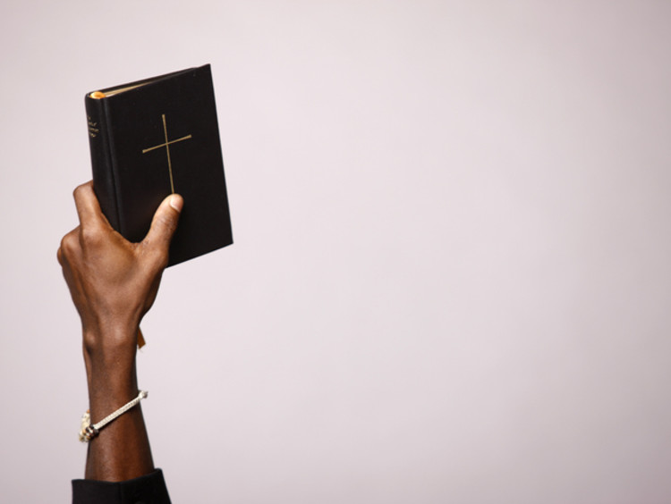 Holding a Bible Up in one hand