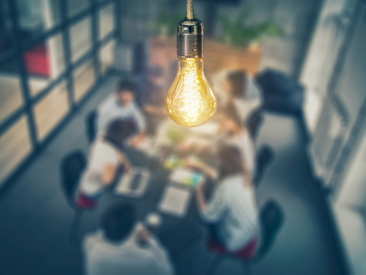 light bulb over team of people