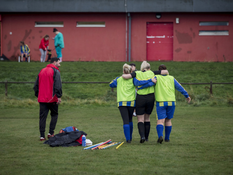 Athletic trainer helping injured student on soccer field