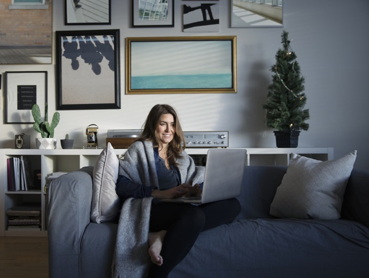 Woman working on laptop in pajamas