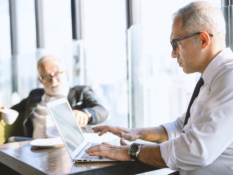 Man works on laptop in coffee shop
