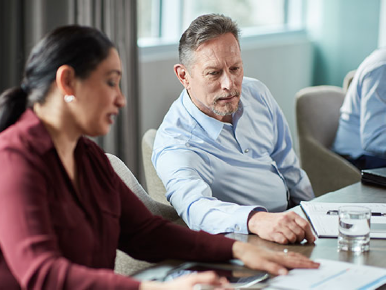 workers discuss numbers in a meeting setting