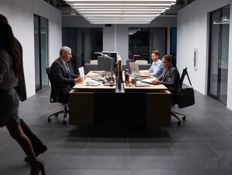 People sit at computers in office meeting setting