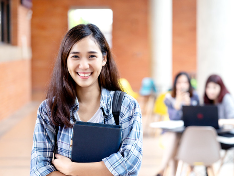 girl smiling holding school notebook